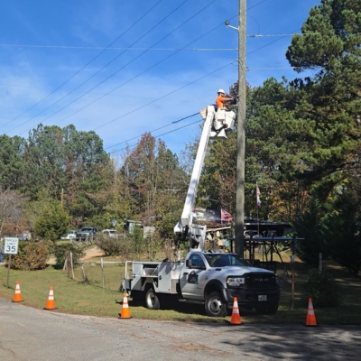 Worker on pole with truck below